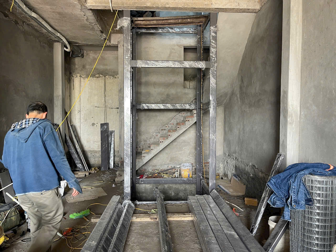 Khung thang máy gia đình bằng thép đang lắp đặt trong nhà xây thô